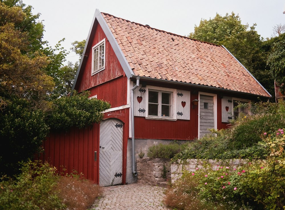 Casa de madera roja entre vegetación